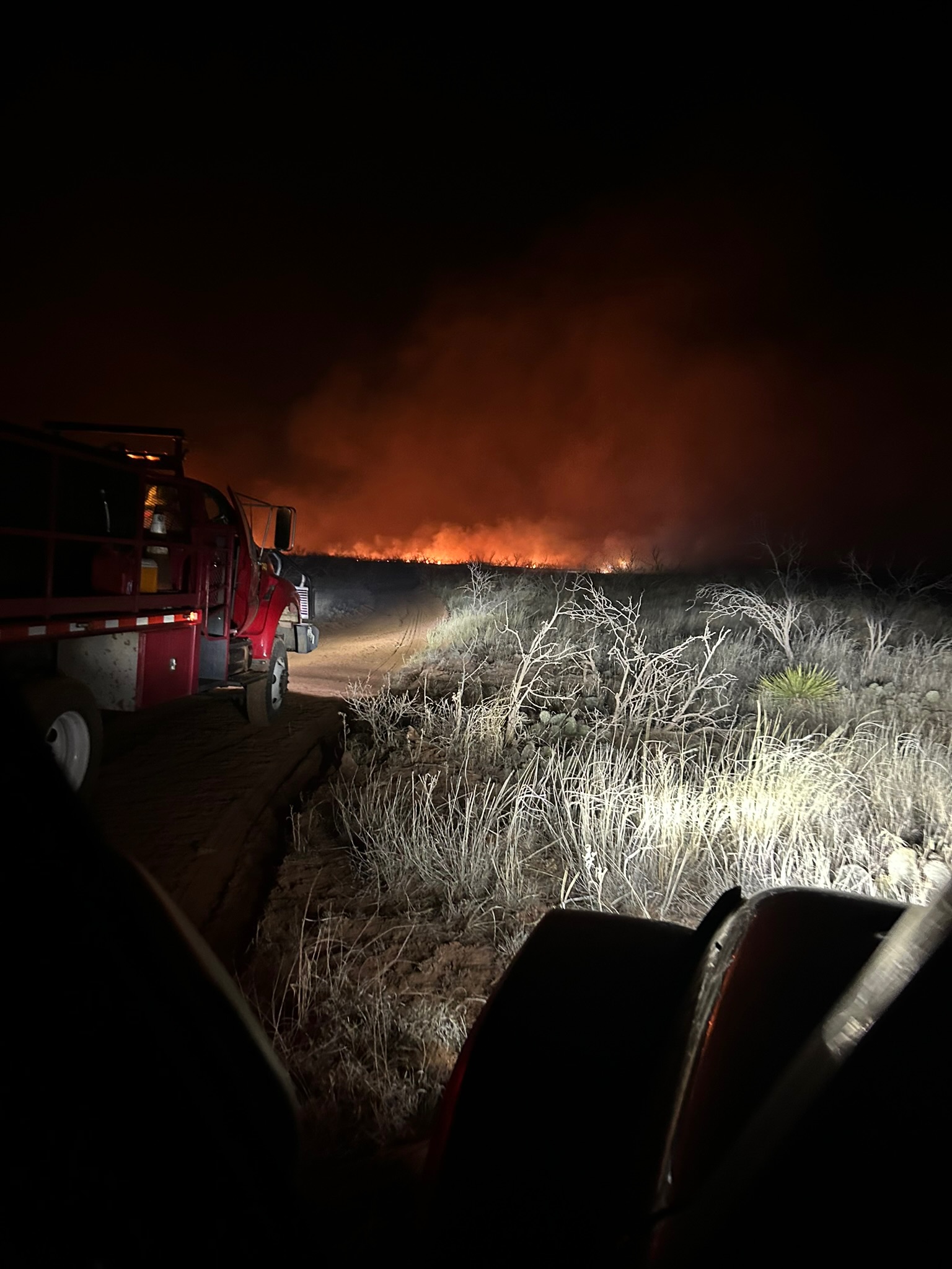 Emergency response truck near a wildfire at night
